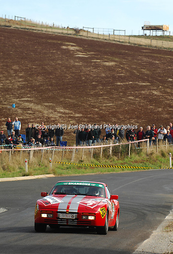 Crowd in paddocks watch cars go through the stage